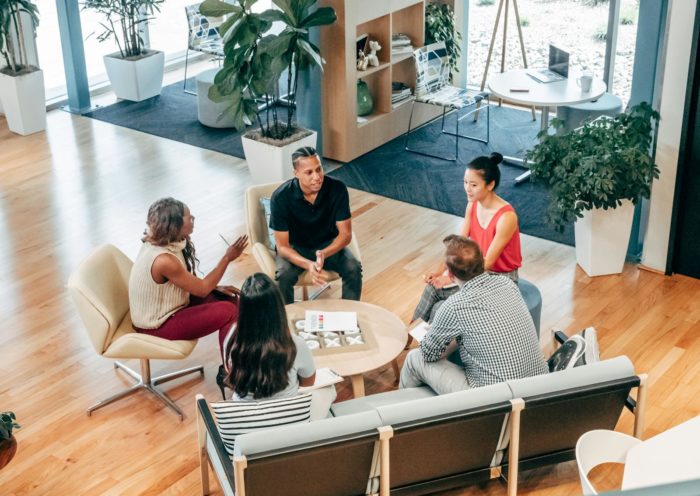 A diverse group of professionals engage in a collaborative team meeting in a stylish office environment.