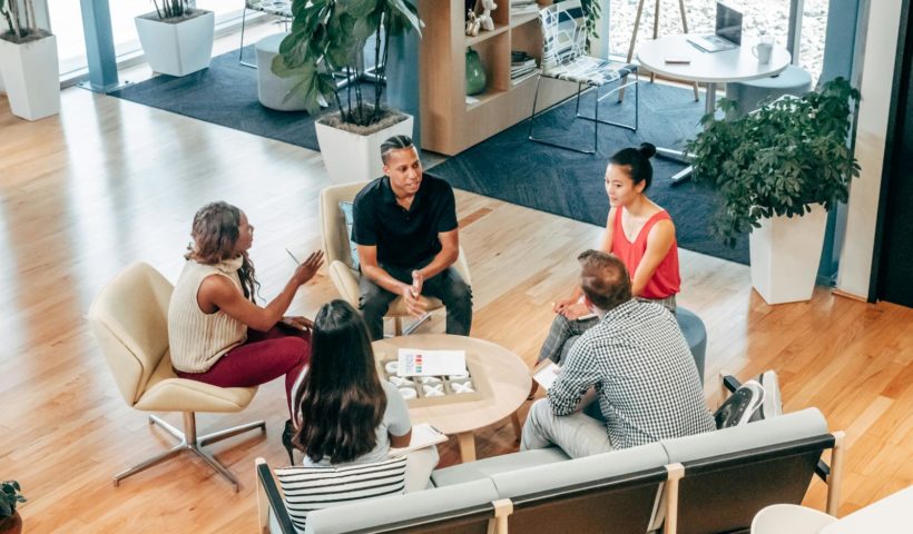 A diverse group of professionals engage in a collaborative team meeting in a stylish office environment.